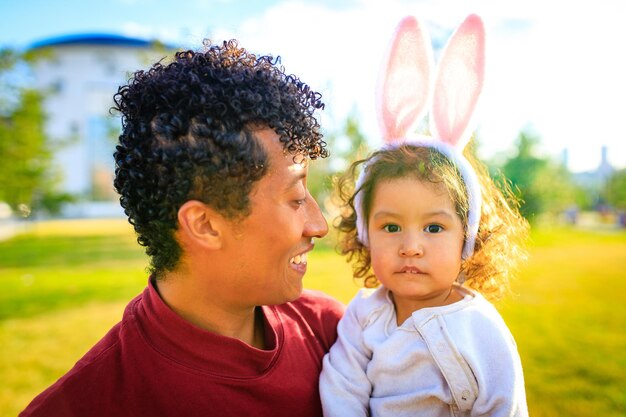 Latin hispanic father and mixed race little girl playing rabbit and hare outdoor