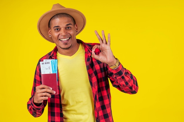 Latin hispanic man holding pasport and ticket in studio