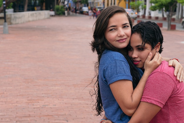 街で抱きしめるラテンレズビアンカップル。 LGBTの概念