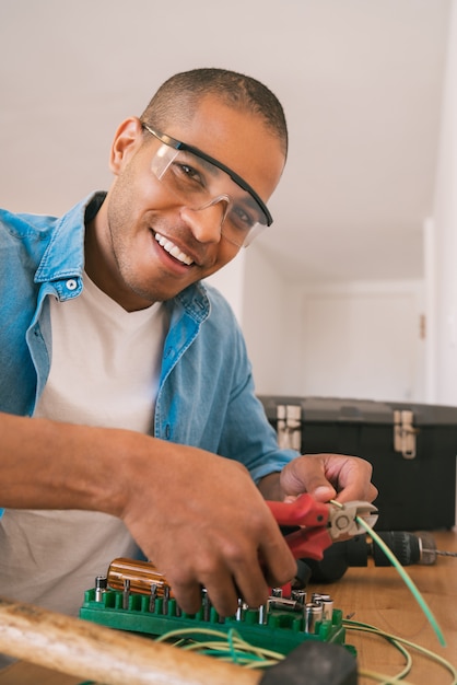 Latin man fixing electricity problem at home.