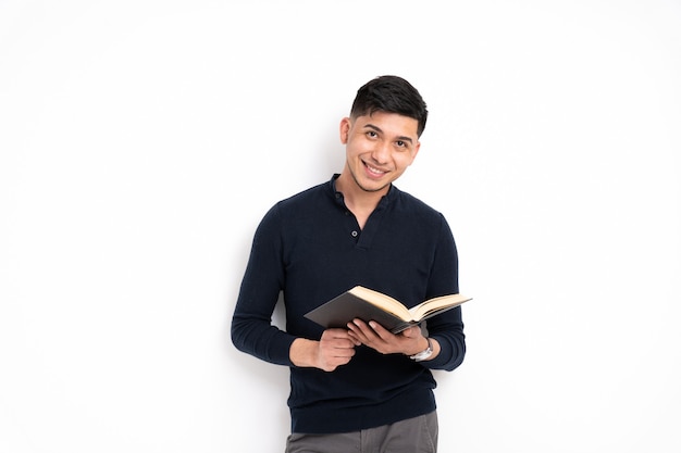 Latin man holding book smiling looking at camera