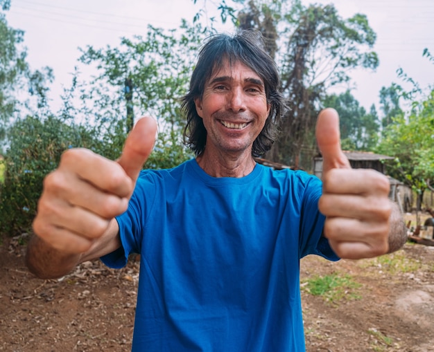 Latin man of indigenous descent on his farm. Brazilian farmer. Thumbs up.