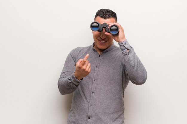 Latin man inviting to come He is holding a binoculars