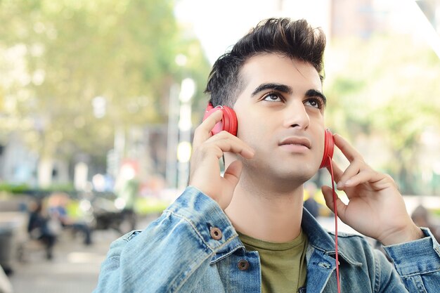 Latin man listening music with headphones.