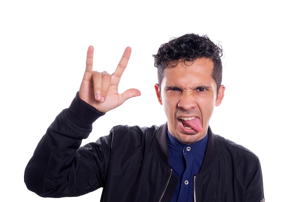 Uomo latino che fa un gesto rocker e tira fuori la lingua isolato su sfondo bianco