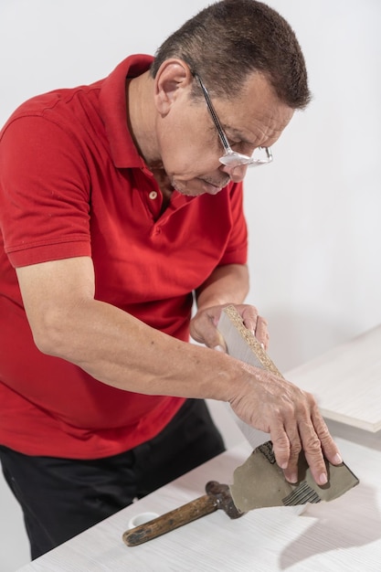 Photo latin man sanding a piece of furniture at home