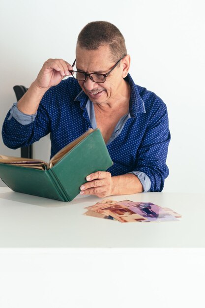 Latin man with photo album, smiling