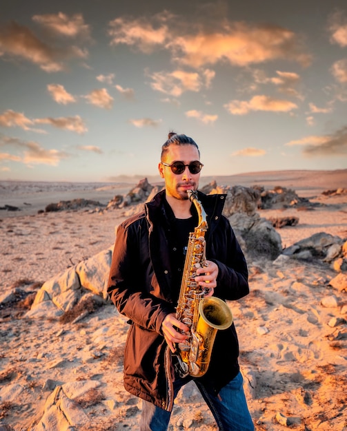 latin musician playing the saxophone in the desert in Atacama Chile