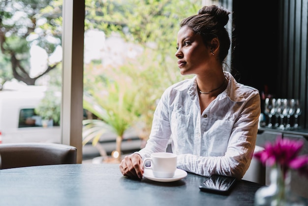 Latin woman in a cafe drinking coffee