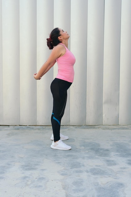 Latin Woman doing stretching exercise during workout in the park.