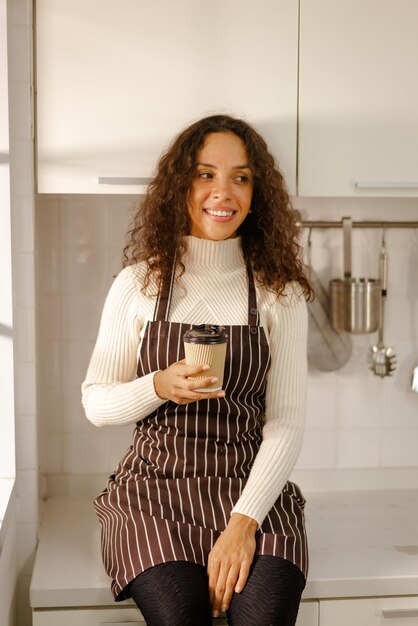 Latin woman drinking coffee in kitchen