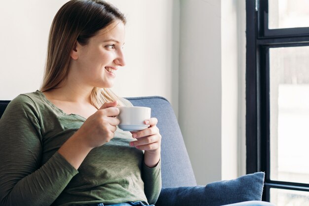 ラテン女性の一杯のコーヒーを楽しむ