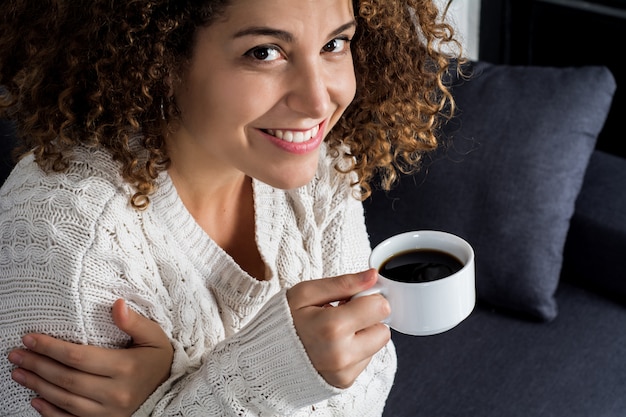 ラテン女性の一杯のコーヒーを楽しむ