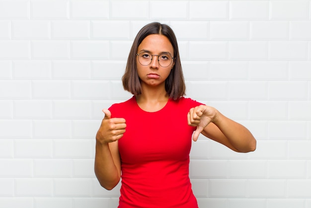 Foto donna latina che si sente confusa, incapace e insicura, valutando il bene e il male in diverse opzioni o scelte