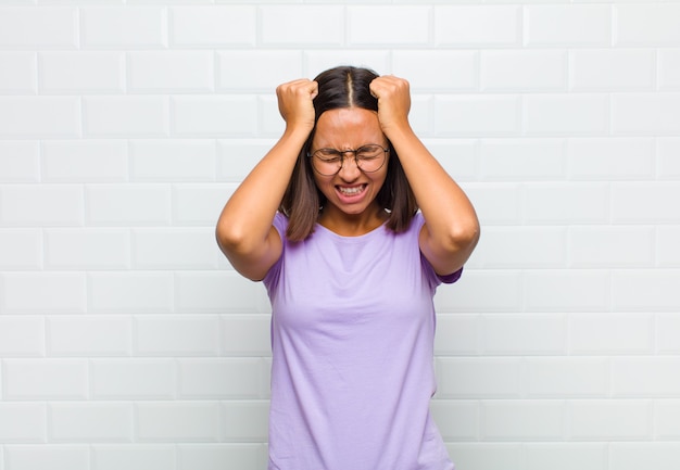 Foto donna latina che si sente stressata e ansiosa, depressa e frustrata con un mal di testa, alzando entrambe le mani alla testa