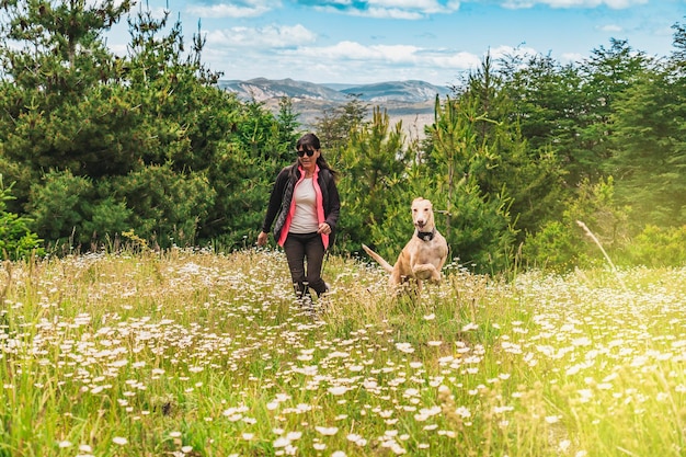 Latin woman and her dog running together