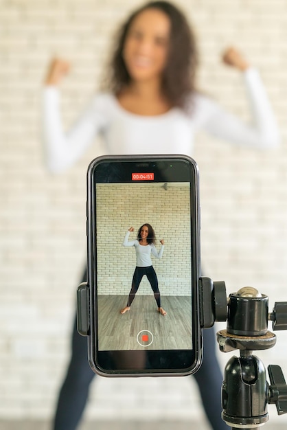 Latin woman influencer maakte haar dansvideo met een smartphonecamera. Om video te delen met sociale media-applicatie.