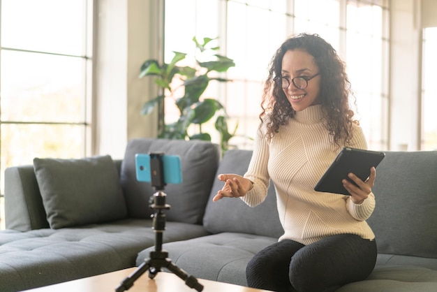 Influencer donna latina che gira video e parla con la fotocamera per blog - concetto di contenuto online