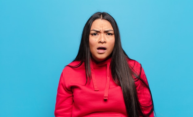 Latin woman looking shocked, angry, annoyed or disappointed, open mouthed and furious