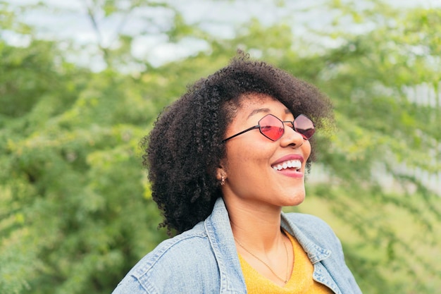 Latin Woman looking up and smiling while posing with green plants on background