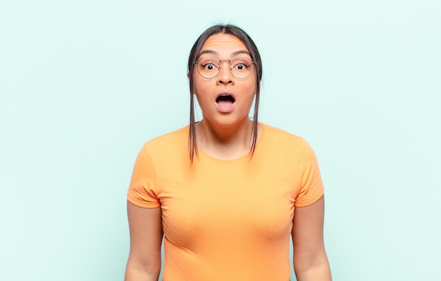 latin woman looking very shocked or surprised, staring with open mouth saying wow