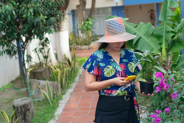 植物の配達にお金を払っているラテン女性。アーバンジャングルコンセプト