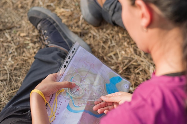 Latin woman reading map and using compass during orienteering race latin young venezuelan