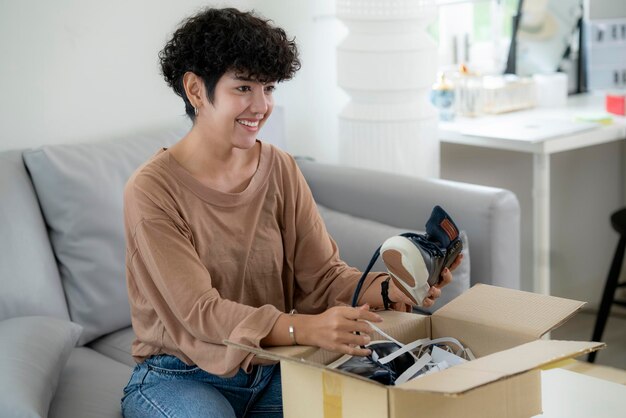 Photo latin woman recive package and unbox open a box and satisfied her shoe form online shop