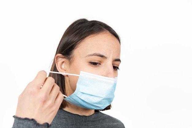 Латиноамериканка снимает медицинскую маску. Здравоохранение во время концепции пандемии коронавируса.