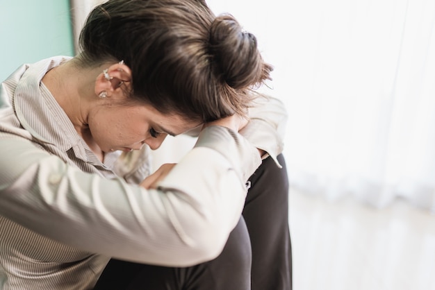 Latin woman sitting on floor feels unhappy by personal problems, break up or ruined marriage