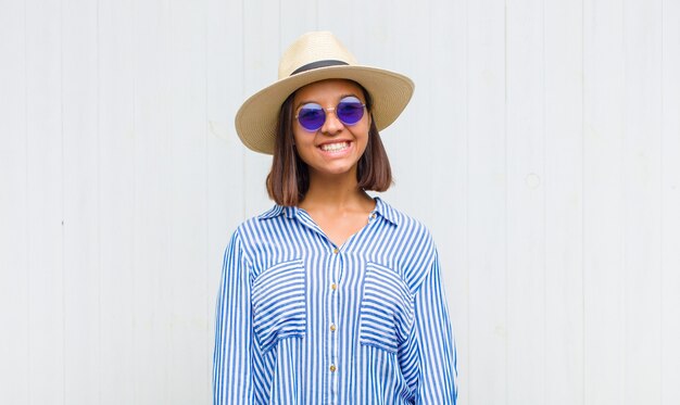 Latin woman smiling cheerfully and casually with a positive, happy, confident and relaxed expression