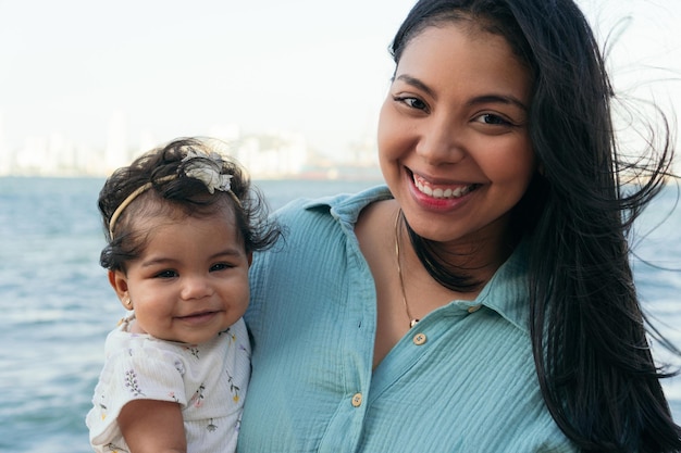 Photo latin woman stands with her baby in the park