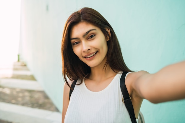 ラテン女性が屋外でselfieを取っています。