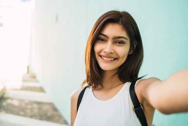 ラテン女性が屋外でselfieを取っています。