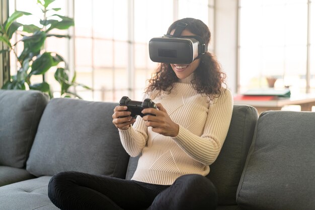 Latin woman using a virtual reality headset on sofa