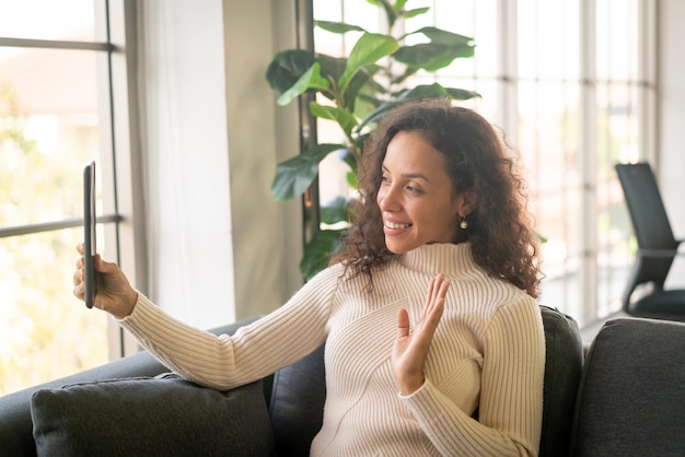 Latin woman video conference on tablet with happy feeling