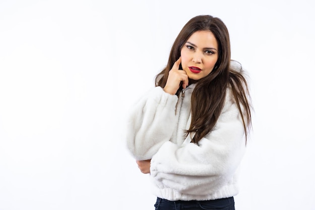 Latin woman with black hair and a white wool sweater photographed in a studio with a white background