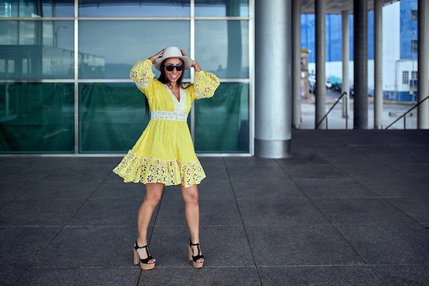 Latin woman in yellow dress dancing in the street of a city.