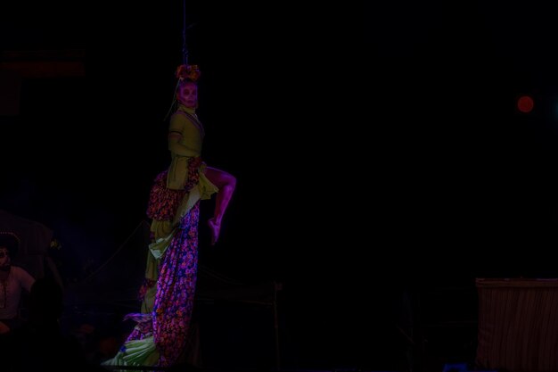 Latin women dancing with colorful fabrics with lights of different shades at night mexico