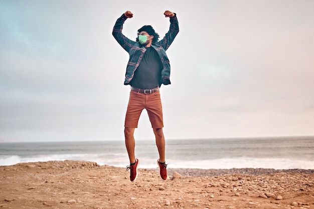 Latin young man poses walking on the sand during a beautiful sunset