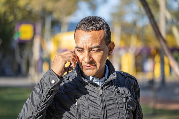 Латинский молодой человек разговаривает по мобильному телефону