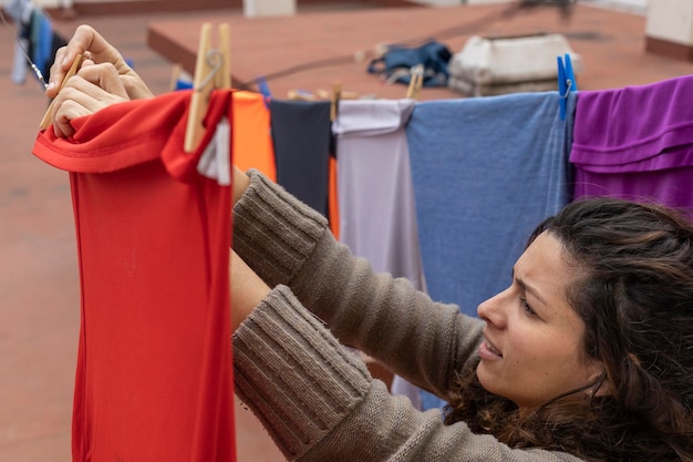 Latina-vrouw die kleren aan de waslijn hangt