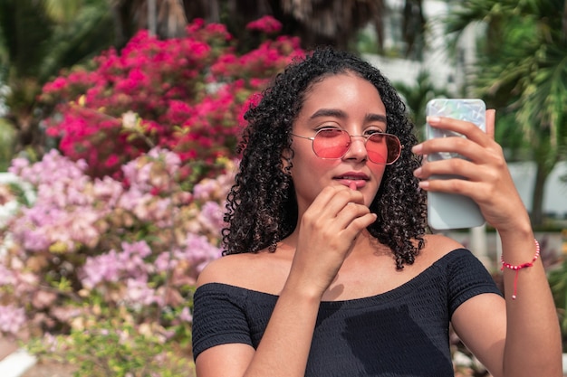 Latina woman applying makeup outdoors