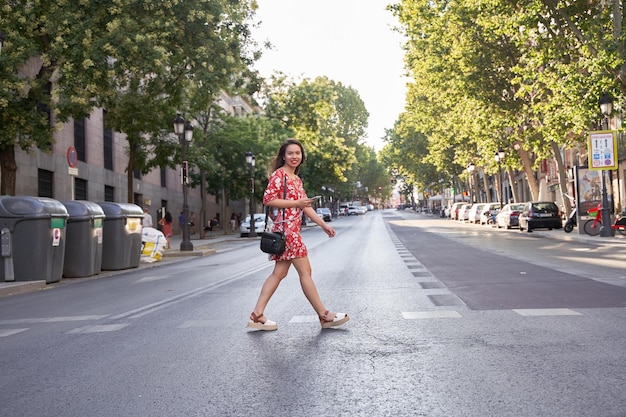 Latina woman crossing the road at the crosswalk