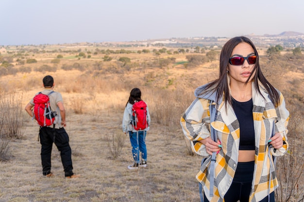 Foto donna latina che si diverte a fare escursioni nel deserto con un gruppo di amici esplorazione e comunità in montagna concetto di escursioni esplorazione della comunità