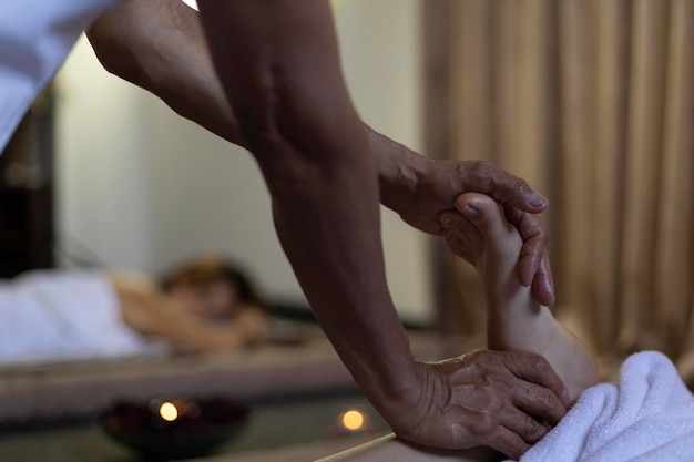Latina woman lying on her back receiving an ayurvedic massage treatment on her feet