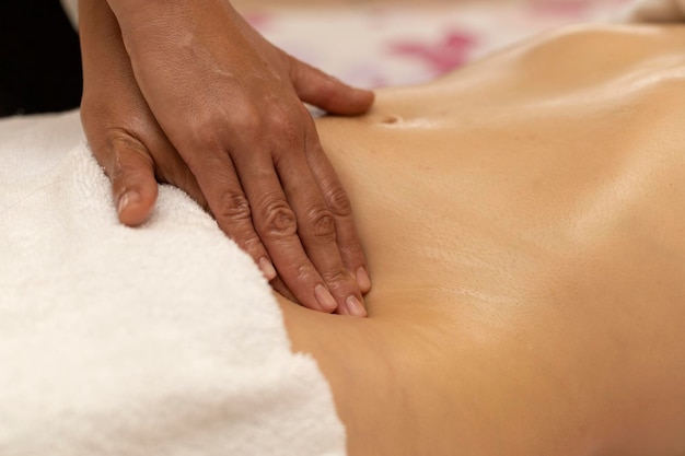 Latina woman receiving a body slimming massage with specific pressure points