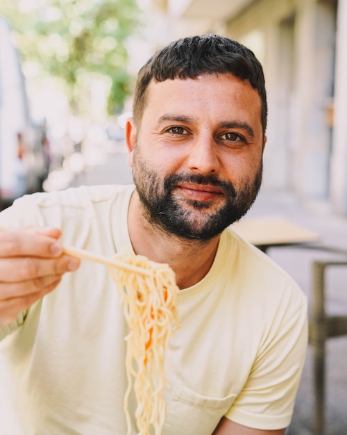 Latino boy in yellow tshirt eating japanese food