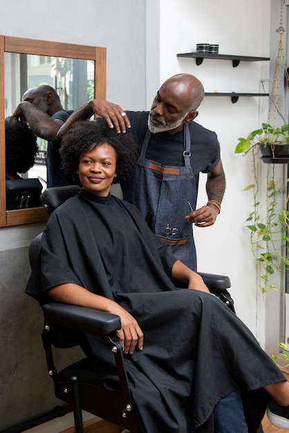 Photo latino hair salon owner taking care of client