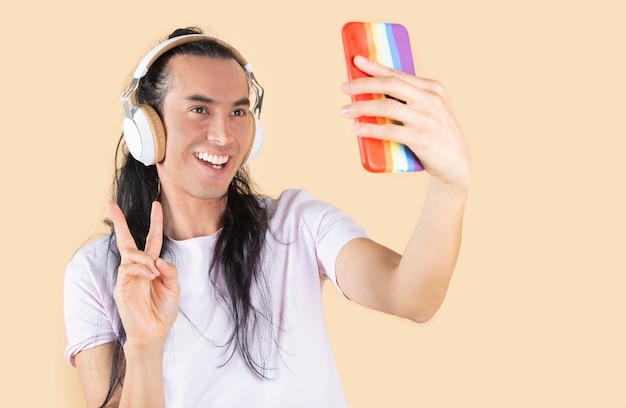 Latino hispanic man takes selfie yellow background